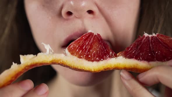 Woman Eating Red Orange Slice Close Up