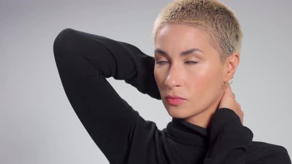 Blonde with Short Haircut in Studio Poses for Camera on Grey Ideal Skin