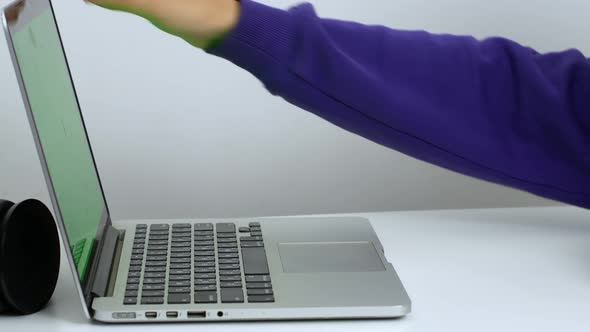 Hands of a mixed-race woman writing a text on a laptop keyboard in close-up.