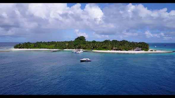 Aerial flying over travel of paradise resort beach voyage by blue sea with bright sandy background o