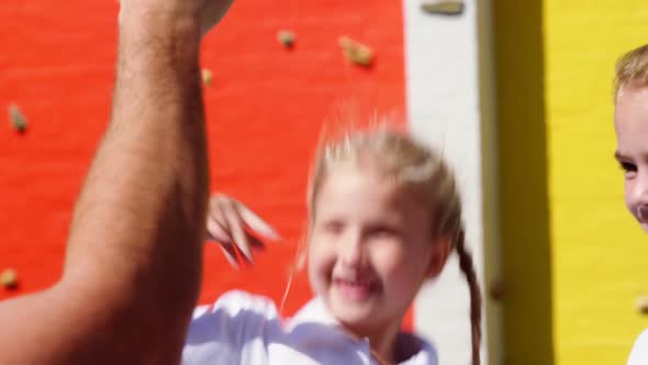 School kids giving high five to coach