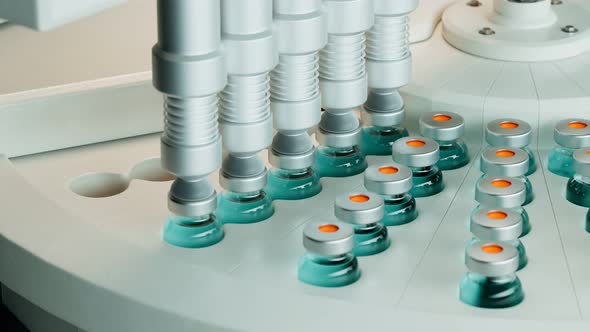 Blue vaccine bottles on the conveyor belt. Concept of COVID-19 vaccination.