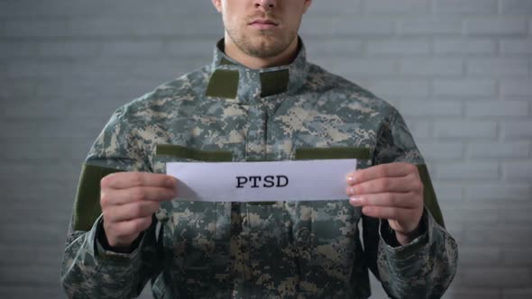 PTSD Written on Sign in Hands of Male Soldier, Posttraumatic Disorder, Health