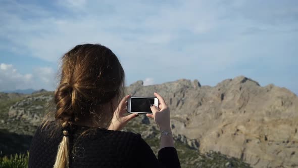 Woman taking pictures in Cap Formentor in Mallorca