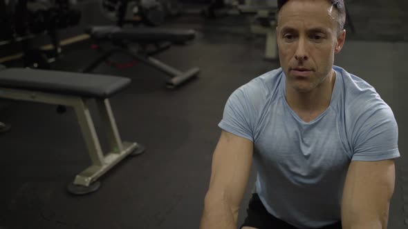 Man doing side-to-side chops exercise with elastic band at the gym.