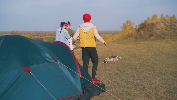 Girls Look at Handsome Guy Going Out of Tent on River Bank