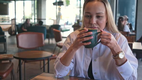 Young Woman Sitting in Cafe Drinking Enjoying Coffee Relaxing