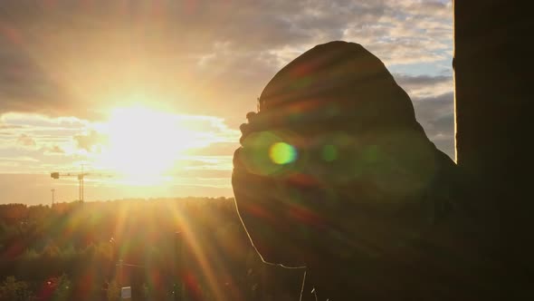 Unrecognizable Bearded Man Puts Off Yellow Hood and Gas Mask and Breath Sun Shines Into Camera