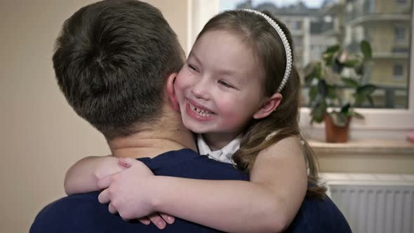 Little Girl Hugs Her Dad with Love and Joy