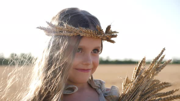 Serious Sad Girl a Child Stands on a Wheat Mown Field