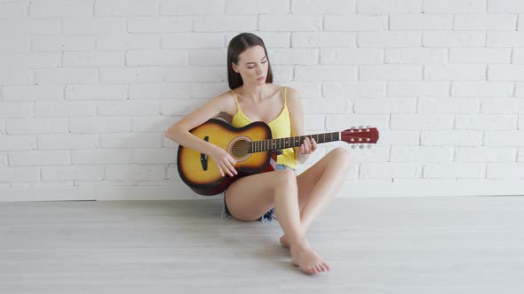 Young Woman with Guitar Looking at Camera