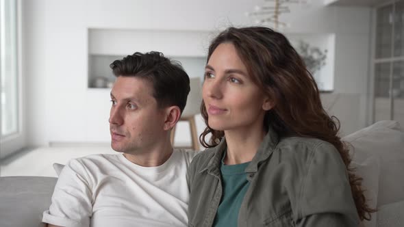 Newlyweds Sit on Sofa and Talk Looking Through Window