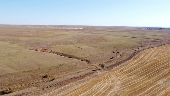 Shooting From a Drone Flying Over Fields Ravines and Meadows with Dried Grass From the Heat