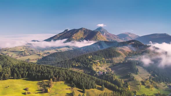 Aerial Alpine Countryside Nature with Misty Clouds in Sunny Autumn Mountains