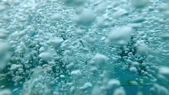 Dreamy POV looking on feet in bubble pool underwater
