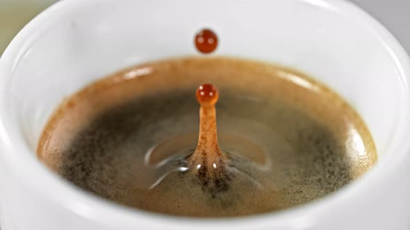 Super Slow Motion Detail Shot of Coffe Drop Falling Into Fresh Espresso at 1000 Fps.