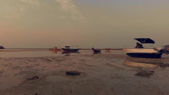 Drone Flight Between Boats in Sunset Low Tide