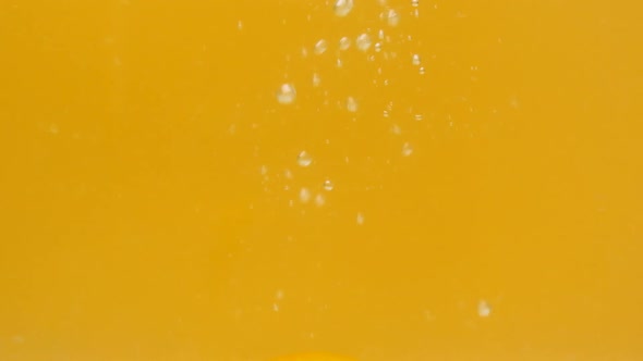 Two Pieces of Lemon Fall Into the Water and Slowly Float and the Top Rises on