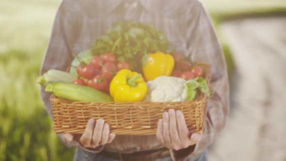 An Old Farmer is Holding a Basket of Vegetables