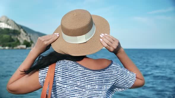 Back View Elegant Travel Woman in Straw Hat Admiring Seascape