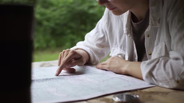 Active Focused Girl Tourist Sits Resting During A Hiking Trip Looking The Map Looking For The Right