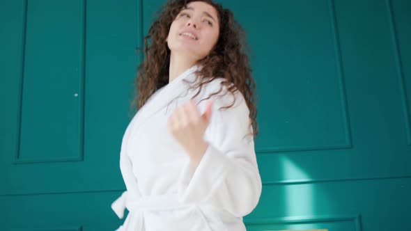 Girl with Curly Hair in Bathrobe Dancing Alone at Home Listening Music