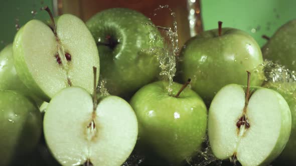 Slow Motion Shot of Green Apple Juice Splashing Through Apple Slices