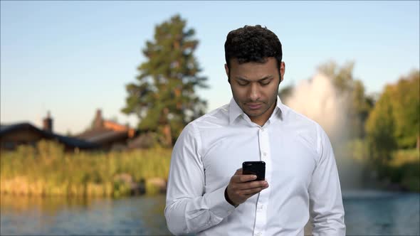 Attractive Man Taking Picture with Smartphone Outdoors.