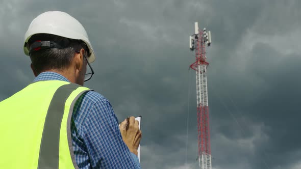 Telecommunications Engineer Checking the Signal From a Telecommunications Tower