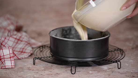 Transfer cheese filling into baking pan. Making cherry cheesecake.