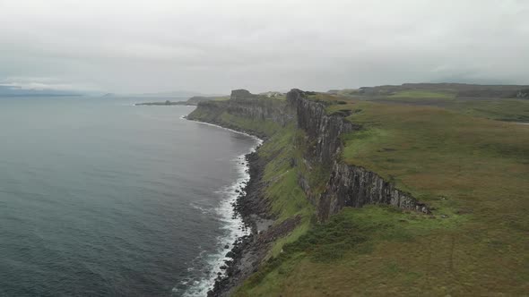 drone shot of coast cliffs in isle of skye scotland, green landscape and calm sea