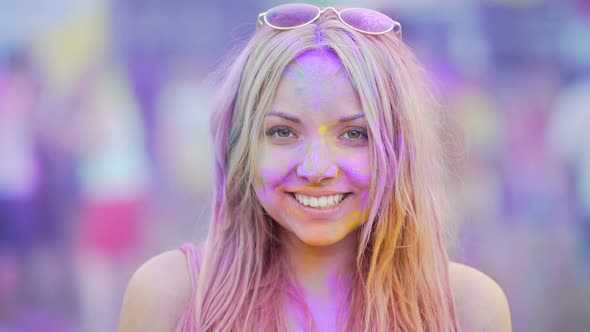 Sincere Smile of Cheerful Young Woman Having Fun at Exciting Color Festival