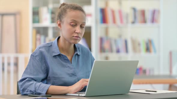 Cheerful African Woman with Laptop Smiling at Camera