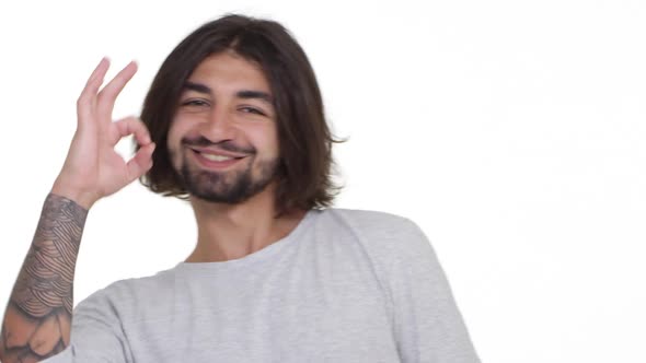 Cool Caucasian Guy Appears in the Frame Showing Ok Isolated Over White Background in Slowmotion