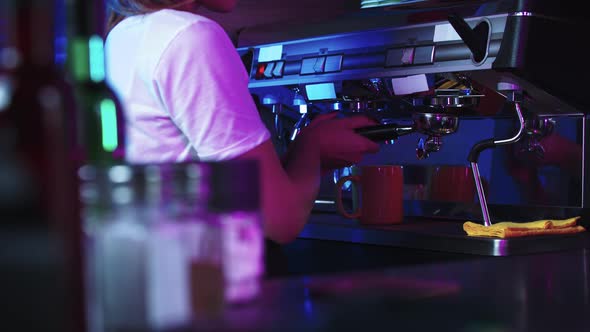 A Woman Barista Working with a Coffee Machine  Cleaning the Machine with Pouring the Water Down