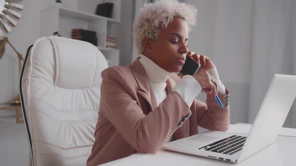 Young African American Woman Manager Talking on Phone with Business Partners