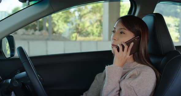 Woman talk to cellphone sit inside car