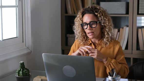 Blond businesswoman having video call on laptop in office