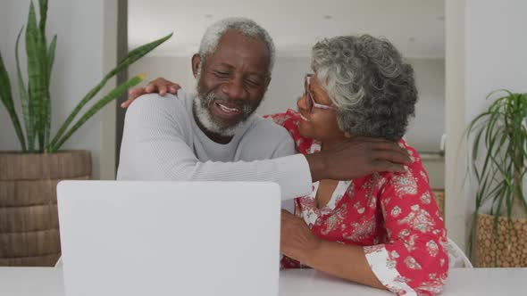A senior african american couple spending time together at home using a laptop. social distancing in