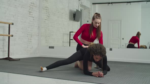 Personal Trainer Helping Woman in Stretching Workout at Gym
