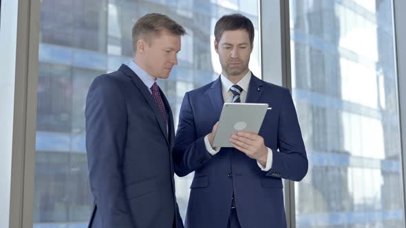 Cheerful Two Middle Aged Businessmen Working on Tablet and Celebrating with Fest