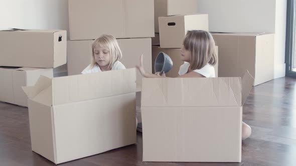 Sweet Pretty Girls Unpacking Things in New Apartment