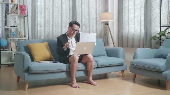 Full View Of Asian Businessman In Jacket And Shorts Presenting Work On A Laptop At Home