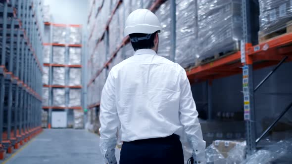 Follow footage of employees male warehouse worker engineer in hard hat working