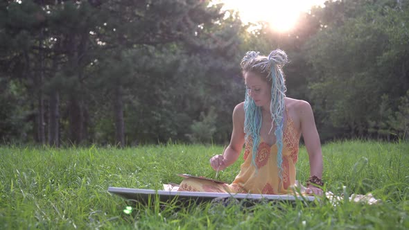 Young Sexy Woman Artist Paints a Picture in the Park in Nature on the Background of Sunset