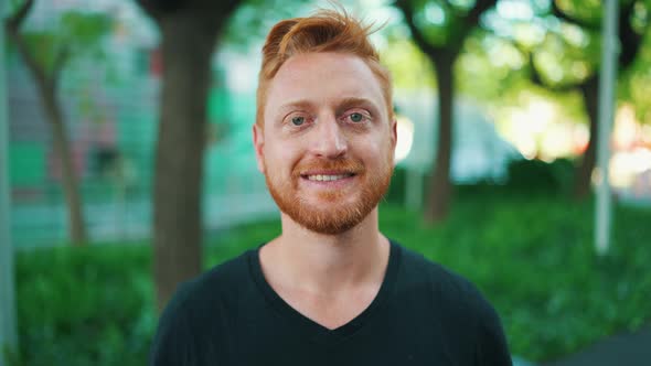 Smiling red haired man looking at the camera