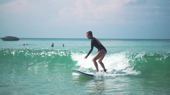 Beautiful Young Woman in Bikini Surfing in Ocean