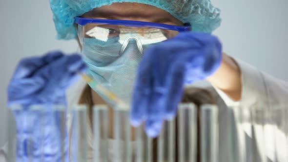 Chemist Checking Acidity Level in Blue Test Liquid With Litmus Paper, Control