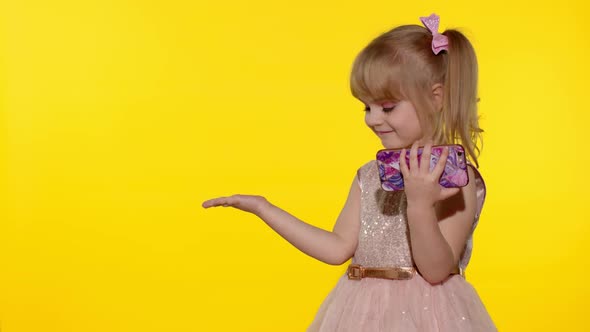 Child girl holding smartphone, Kid pointing at something with hands, showing, offering a product