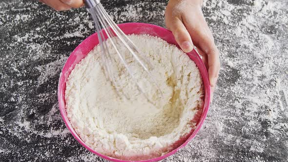 Woman whisking flour in bowl